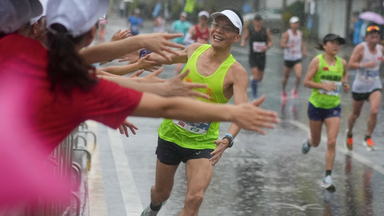 Marathon runners brave the downpour in Yantian